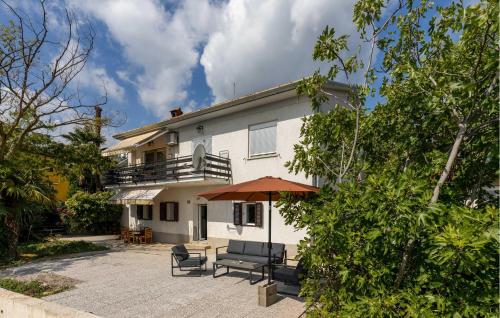 a house with a patio with a table and an umbrella at Lovely Apartment In Opric-Lovran With Wifi in Opric
