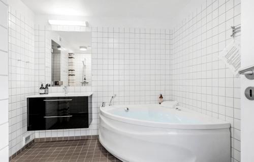 a white bathroom with a tub and a mirror at Stunning Home In Gråsten With Sauna in Gråsten