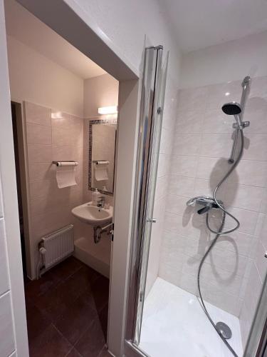a bathroom with a shower and a sink at Hotel Ideal in Lübeck