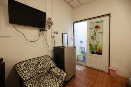 Ban Don Muang (1)にあるBanana Hostel Donmuangの壁にテレビと椅子が備わる客室です。