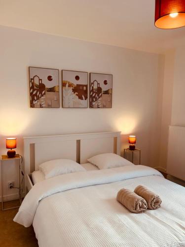 two beds in a bedroom with three pictures on the wall at Appartement cosy près de Disneyland Paris in Serris