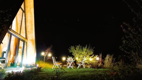 a table and chairs in a yard at night at ZenFrame Cabin in Tarčin