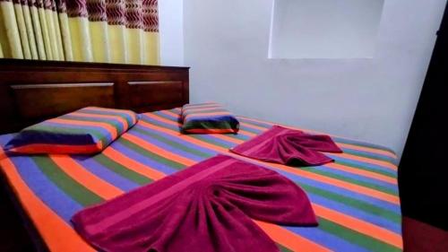 a colorful bed with colorful sheets and pillows on it at Kelaniya Guest House in Peliyagoda