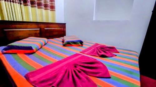 a colorful bed with colorful sheets and pillows on it at Kelaniya Guest House in Peliyagoda