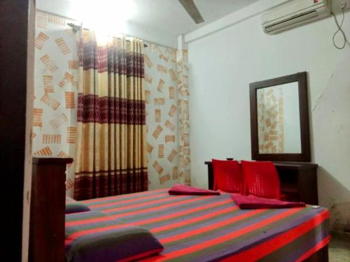 a bedroom with a bed with red pillows at Kelaniya Guest House in Peliyagoda