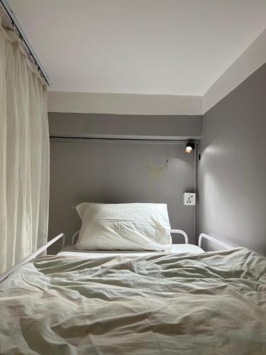 a white bed in a room with a window at Bed and Pillow Hostel in Kathmandu