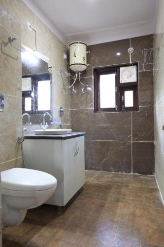 a bathroom with a toilet and a sink at Nature Roar Forest Resort ,Nainital in Nainital