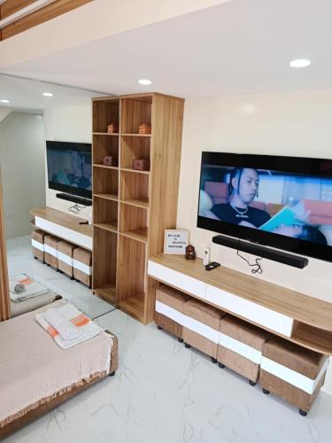 a living room with a large flat screen tv at The Tree House - Connecting Loft Units Govantes in Vigan
