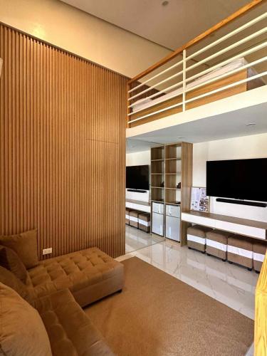 a living room with a couch and a flat screen tv at The Tree House - Connecting Loft Units Govantes in Vigan