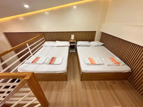 two beds in a small room with a staircase at The Tree House - Connecting Loft Units Govantes in Vigan