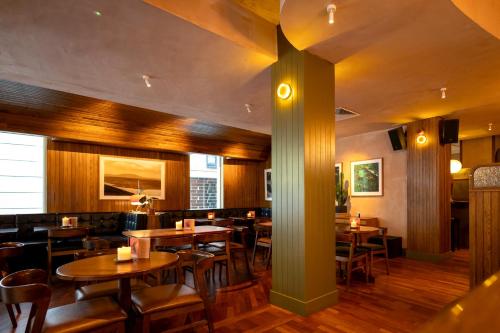 a restaurant with wooden floors and tables and chairs at Drury Court Hotel in Dublin