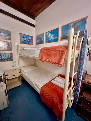 a bedroom with two bunk beds and a desk at Casa Oliva Ansedonia in Ansedónia