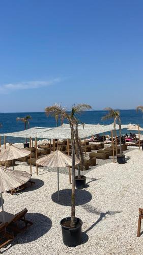 a group of tables and umbrellas on a beach at Blue Bay Residence in Vlorë