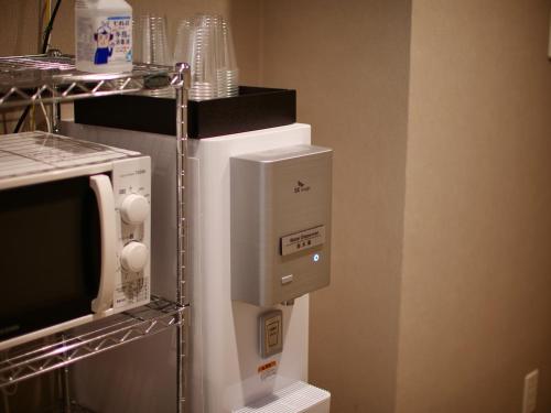a coffee machine in a room with a microwave at Henn na Hotel Premier Kyoto Gojo Karasuma -Formerly Watermark Hotel Kyoto- in Kyoto