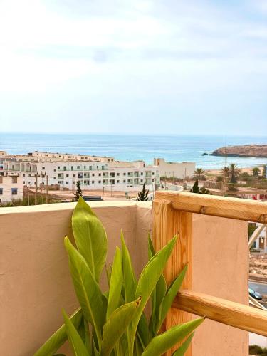 a view of the ocean from a balcony with a plant at Balance Surf Morocco , Quality rooms , Moroccan food , Activities in Aourir