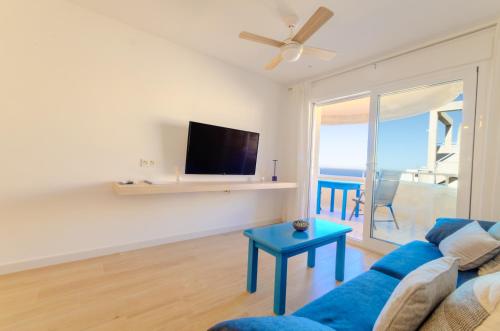 a living room with a blue couch and a tv at Garrucha Blue Horizon in Garrucha
