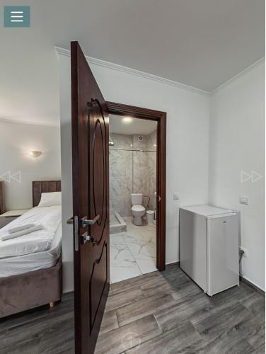 a bedroom with a bed and a door leading to a bathroom at Spa Hotel Alpin in Solotvyno