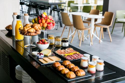 uma mesa com vários tipos diferentes de alimentos em Okko Hotels Bayonne Centre em Baiona