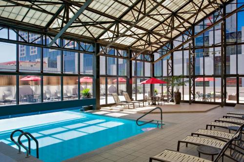 a pool in a building with tables and chairs at San Antonio Marriott Riverwalk in San Antonio