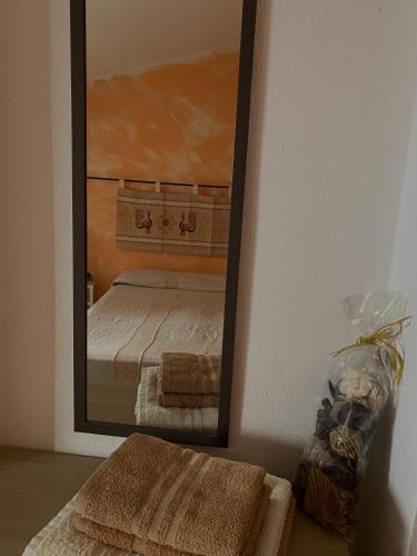 a mirror on a wall with a bed in a room at B&B Pudzones in Santu Lussurgiu