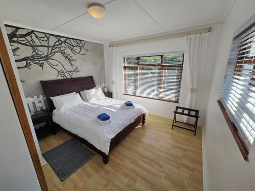 a bedroom with a bed with two blue bowls on it at Volgens Plan Family Holiday Home in Little Brak River in Reebok