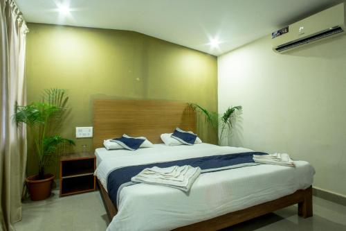 a bedroom with a large bed with blue pillows at Kartik Resort in Mandrem