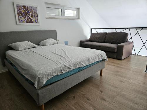 una camera da letto con un letto, un divano e una sedia di Apartment Blue Mediteran a Mlini