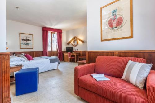 a hotel room with two beds and a red couch at Hotel Duomo in Orvieto