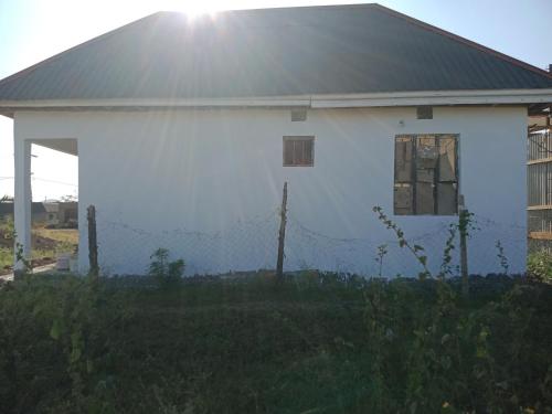 a white house with a fence in front of it at World Heart Africa Experience in Arusha