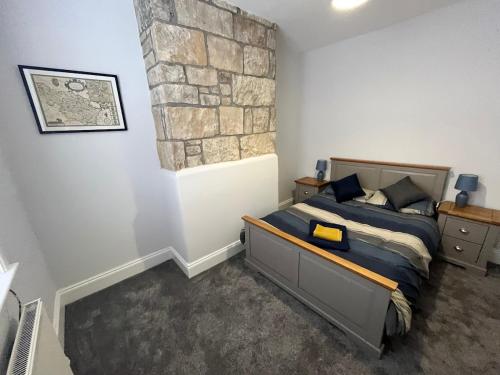 a bedroom with a bed and a stone wall at Mulberry Court At Hollins Mount - 174 Hollins Rd in Walsden