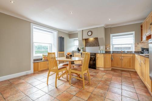 a large kitchen with a table and chairs in it at Kilmore Paws and Relax in Comrie