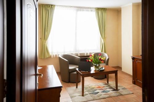 a living room with a chair and a table with a laptop at Central West Hotel in Sofia