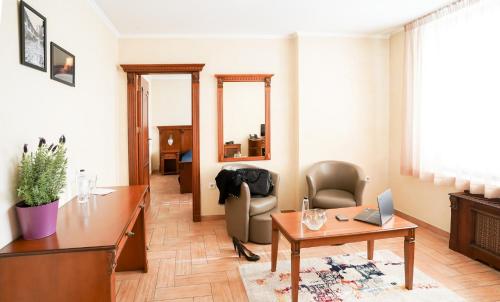 a living room with a desk and a chair at Central West Hotel in Sofia