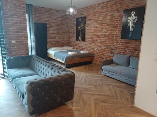 un salon avec un canapé et un lit dans l'établissement Apartament Loft & glow Montownia, à Gdańsk