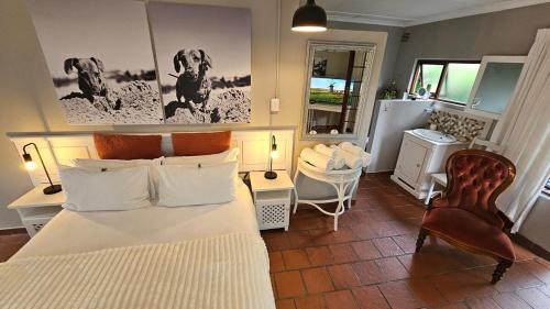a bedroom with a bed and a table and chairs at Pet-Friendly Courtyard Suite Tsitsikamma Gardens in Sanddrif