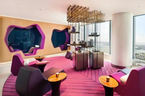 a room with purple chairs and tables and windows at W Suzhou - Jinji Lake in Suzhou