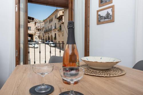 a bottle of wine sitting on a table with two glasses at Apartamento rural Ca La Rumbeta en La Fresneda in La Fresneda