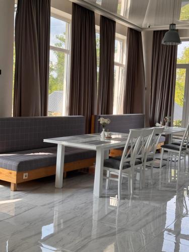 a dining room with a white table and chairs at Spa Hotel Alpin in Solotvyno