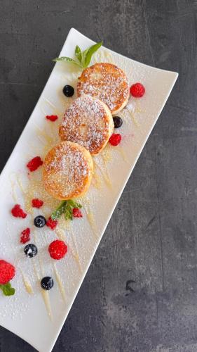 a white plate topped with fruit on a table at Spa Hotel Alpin in Solotvyno