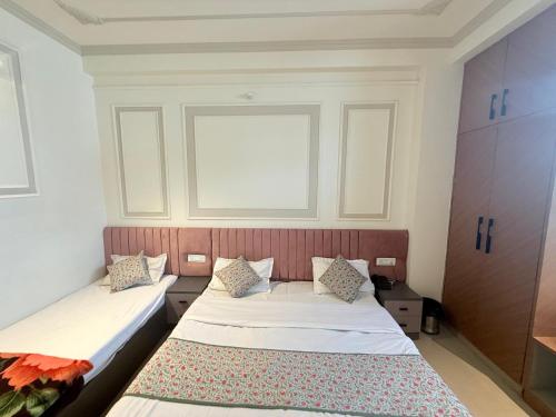 a bedroom with two beds and a window at Shanti Vilas Hotel in Jaipur