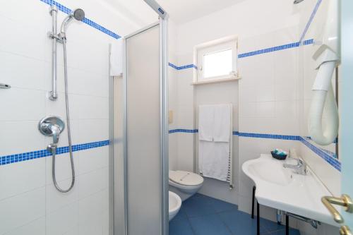 a bathroom with a shower and a toilet and a sink at Hotel La Sorgente in Savelletri di Fasano