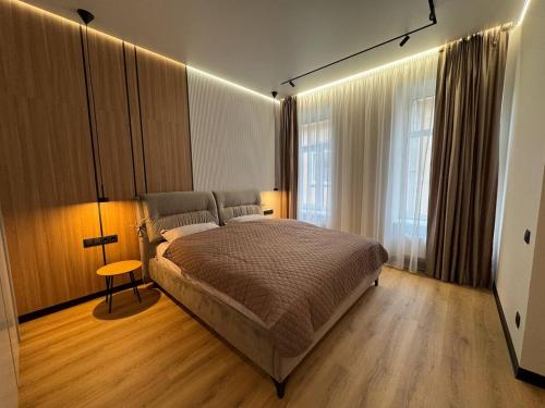 a bedroom with a large bed and a large window at Апартаменти на Площі Ринок in Lviv