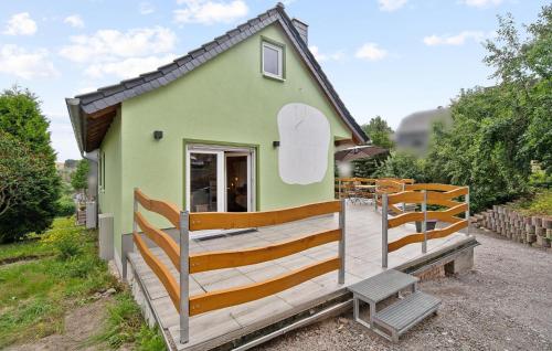 a small green house with a porch and a bench at Cozy Home In Großbreitenbach With Wifi in Großbreitenbach