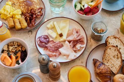 a table topped with plates of breakfast foods at The Social Hub Rotterdam in Rotterdam