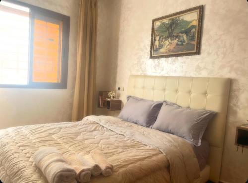 a bedroom with a large bed with a picture on the wall at Appartement-suite- de standing 10 min de la plage in Agadir