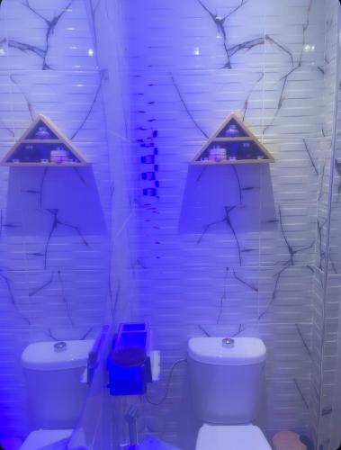 a white bathroom with a toilet and a sink at Appartement-suite- de standing 10 min de la plage in Agadir