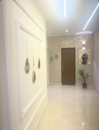a hallway with a white door and a plant at Appartement-suite- de standing 10 min de la plage in Agadir