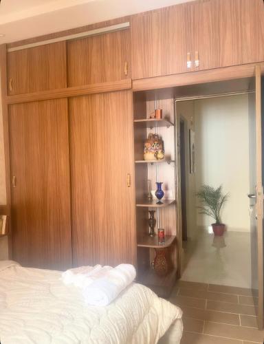 a bedroom with a bed and a wooden wall at Appartement-suite- de standing 10 min de la plage in Agadir