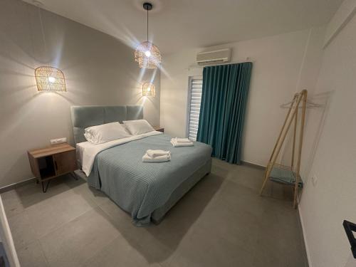 a bedroom with a bed with two towels on it at Perlia Cozy Apartment in Poros
