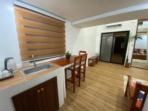 a kitchen with a sink and a counter with chairs at The River House - Govantes Guesthouse in Vigan